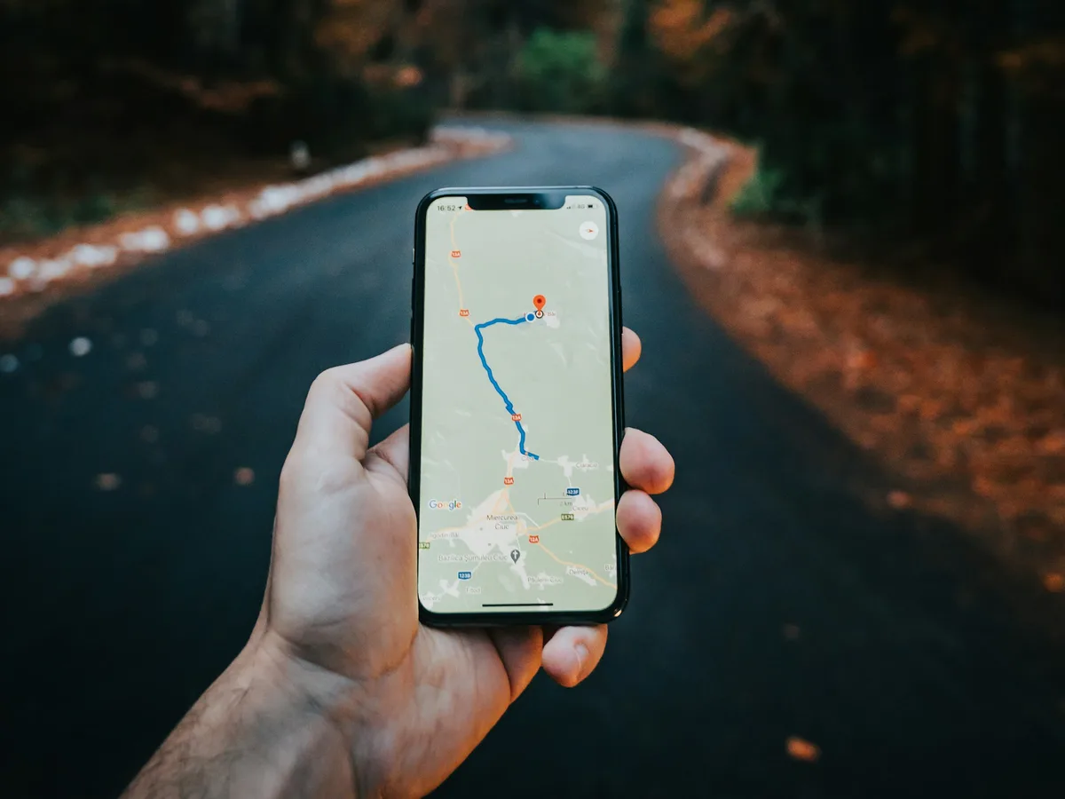 Hand holding a phone showing a route on a map