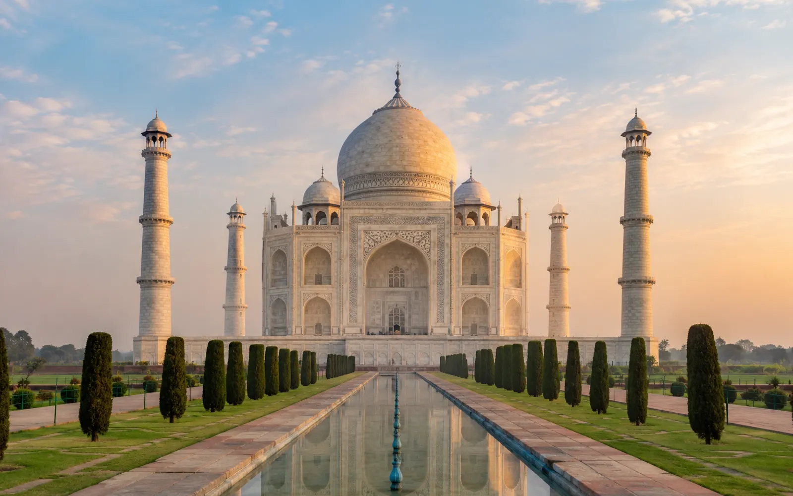 The Taj Mahal at sunrise, reflected in its long pool